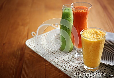 Glassware of tasty smoothies on wooden table Stock Photo