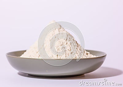 a glazed terracotta bowl containing wheat flour ready to be kneaded. Stock Photo