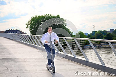 Gleeful businessman enjoying his ride on an electric scooter Stock Photo