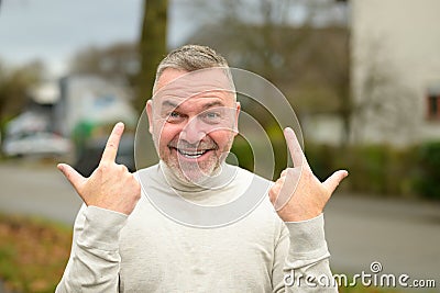 Gleeful elated man grinning at the camera while gesturing Stock Photo
