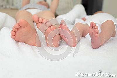 Glegs sisters close-up. baby foot close-up. Sisters are on the bed Stock Photo