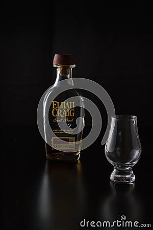 A glencairn glass accompanied by a small bottle of bourbon Editorial Stock Photo