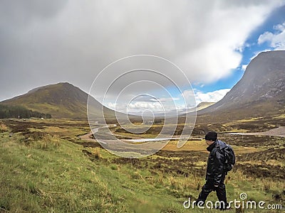 Glencoe, Scotland - May 18 2017 : Man is hiking through the rain in Glencoe, Scotland Editorial Stock Photo