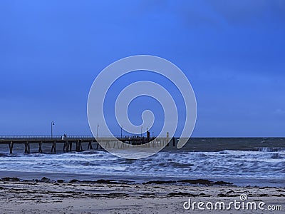 Glenelg jetty and beach under the storm with thick cloud and blue tone Stock Photo