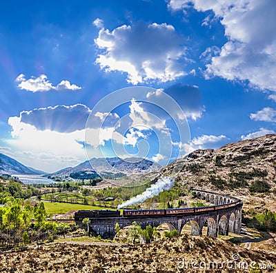 Glenfinnan Railway Viaduct in Scotland with the Jacobite steam train against sunset Stock Photo