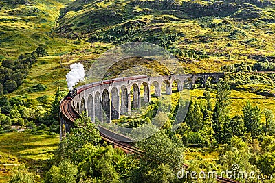 Glenfinnan Railway Viaduct in Scotland with a steam train Stock Photo