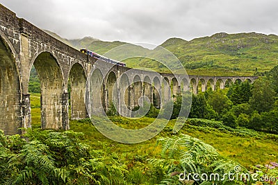 Glenfinnan Viaduct from side on cloudy day with passing train Stock Photo