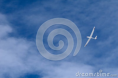 A glider flying across the blue sky Stock Photo