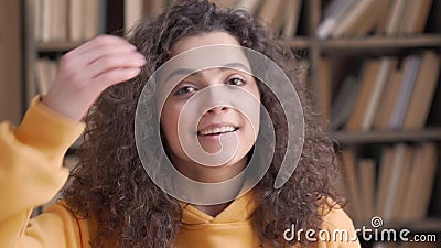 Glimlachende hispanische leerling van de middelbare school die camera ' s dicht bij het portret bekijkt. stock footage Glimlachende hispanische leerling van de middelbare school die camera ' s dicht bij het portret bekijkt. stock footage