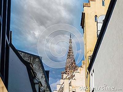 Historic Cathedral Spire Over Rooftops Stock Photo