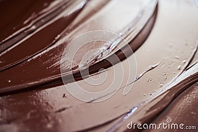 Glistening melted chocolate spread out on a table Stock Photo