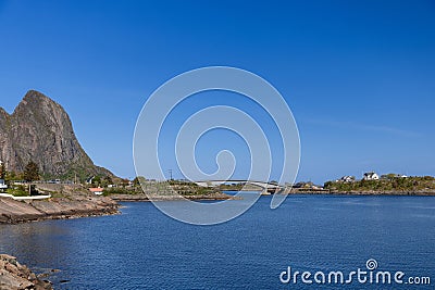 Glistening waters of the Norwegian Sea by Lofoten Islands, Norway, with a graceful bridge under clear skies Stock Photo