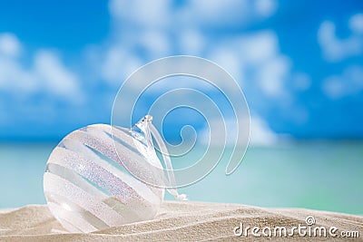 Glitter christmas glass ball on beach with seascape background Stock Photo