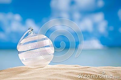 Glitter christmas glass ball on beach with seascape Stock Photo