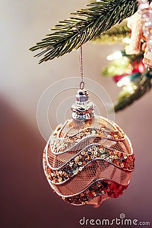 Glitter and mesh Christmas gold and pink ornament hanging from tree Stock Photo