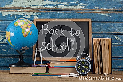 Globe, alarm clock, pencils, chalk, books and slate with back to school text Editorial Stock Photo