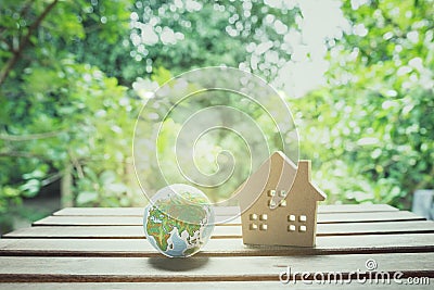 Home model and globe ball in nature background Stock Photo