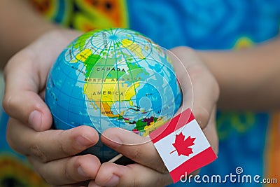 Globe in hand with the Canada flag Stock Photo