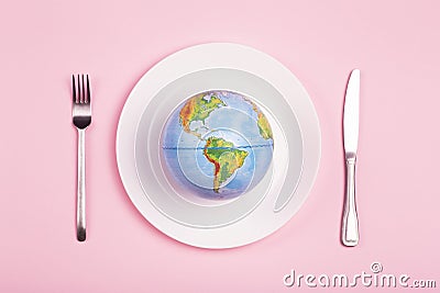 Globe on a plate for food on a pink background. Power, economy, politics, globalism, hunger, poverty and world food concept Stock Photo