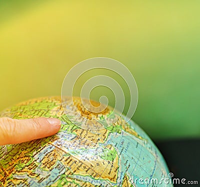 A globe world map with an index finger on it Stock Photo