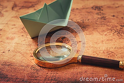 Globetrotter or Journey Explore Concept, Magnifier Glass and Paper Boat Layout on World Map Background, Still-Life Creative Idea., Stock Photo