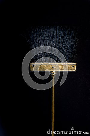 Gloden small cooper broom on black background Stock Photo