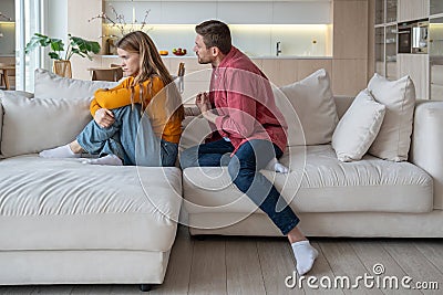 Gloomy upset offended wife and justifying husband having tension, misunderstanding in relations Stock Photo
