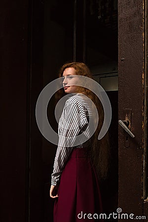 Glorious young red haired model wearing white striped shirt and Stock Photo
