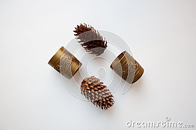 Glossy golden candle holders and pine cones Stock Photo