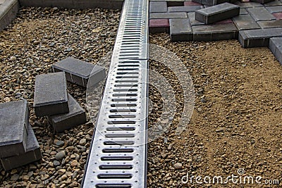 A gloved craftsman lays paving stones in layers. Brick paving slabs for professional use. Laying gray concrete paving slabs in the Stock Photo