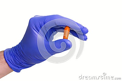 A gloved doctor hand with the vaginal rectal suppository. A medical treatment, application of antibacterial or hemorrhoids candle. Stock Photo