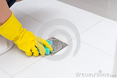 Gloved hand cleaning shower bath drain Stock Photo