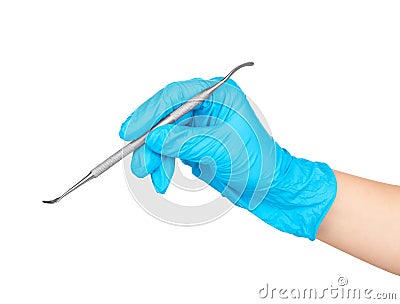 Gloved hand holding a metal dental tool trowel two-way, Stock Photo