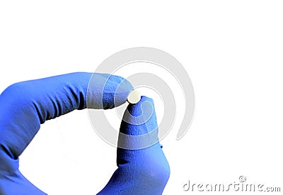 Gloved hand holding a pill Stock Photo