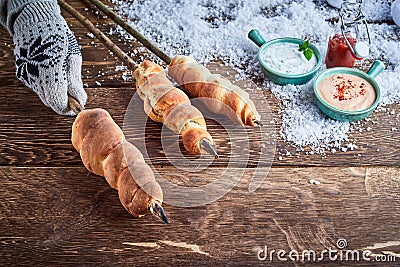 Gloved hand holding a skewer of twist bread Stock Photo