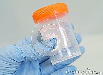 Gloved hand holding specimen bottle Stock Photo