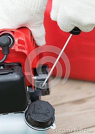 Gloved hand includes a lawnmower, close-up Stock Photo