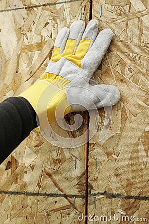 Gloved Hand and Plywood Wall Stock Photo