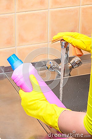 Gloved hand with a rag and cleaning products Stock Photo