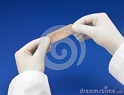 Gloved hands applying bandaid Stock Photo