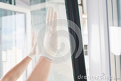 Gloved hands of a craftsman install glass in a plastic window frame Stock Photo