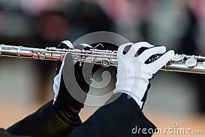 Gloved hands of a flute player in a marching band Stock Photo