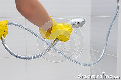 Gloved hands spraying with adjustable shower head Stock Photo