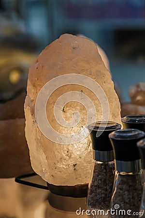 Glow salt lamp, dark vintage wooden background, selective focus. Stock Photo