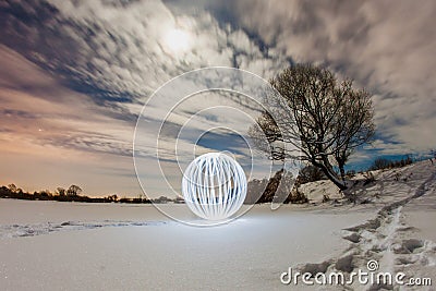 Glowing ball on the surface of a frozen lake Stock Photo