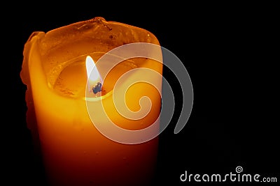 Glowing Candle Against a Black Background Stock Photo