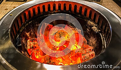 Glowing and flaming hot natural wood charcoal in BBQ grill stove background Stock Photo