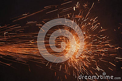 Glowing flow of sparks in the dark. Process of working with metal. Splatter Stock Photo