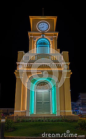 Glowing and illuminated Clock tower on a roundabout in old phuket town at night phuket thailand. Stock Photo