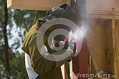 Glowing light of welder welding steel beam Editorial Stock Photo